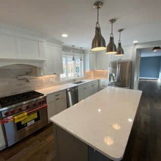 Bright kitchen with quartz island and pendant lights. Home addition project by Potts Brothers Construction, Arlington & Northern Virginia