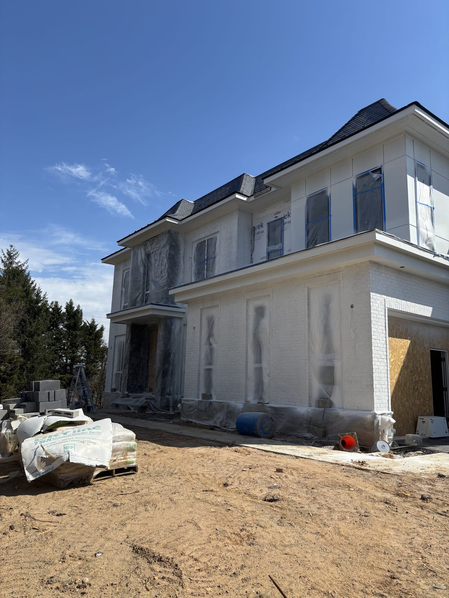 Corner of large white custom home with primed. Home addition project by Potts Brothers Construction, Arlington & Northern Virginia