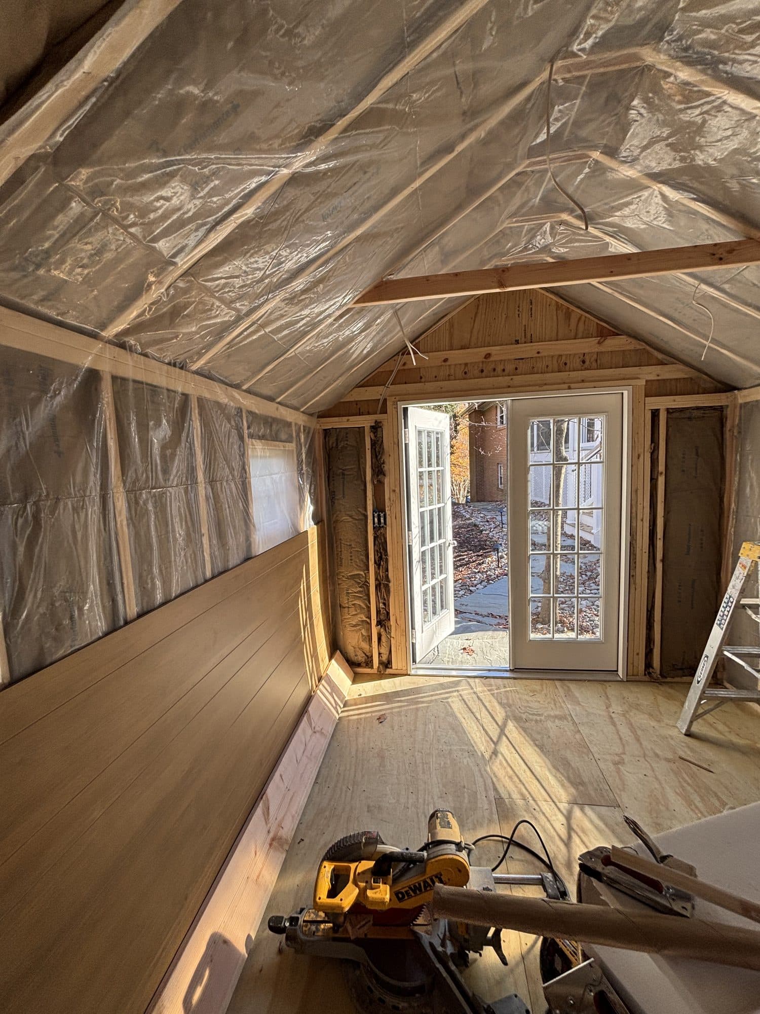 An insulated addition interior with a vaulted ceiling and new French doors opening to the yard. Home addition project by Potts Brothers Construction, Arlington & Northern Virginia