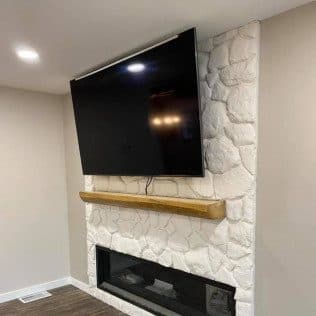 Interior remodel with stone fireplace and mounted television. Home addition project by Potts Brothers Construction, Arlington & Northern Virginia