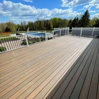 Large composite deck overlooking pool and yard. Home addition project by Potts Brothers Construction, Arlington & Northern Virginia