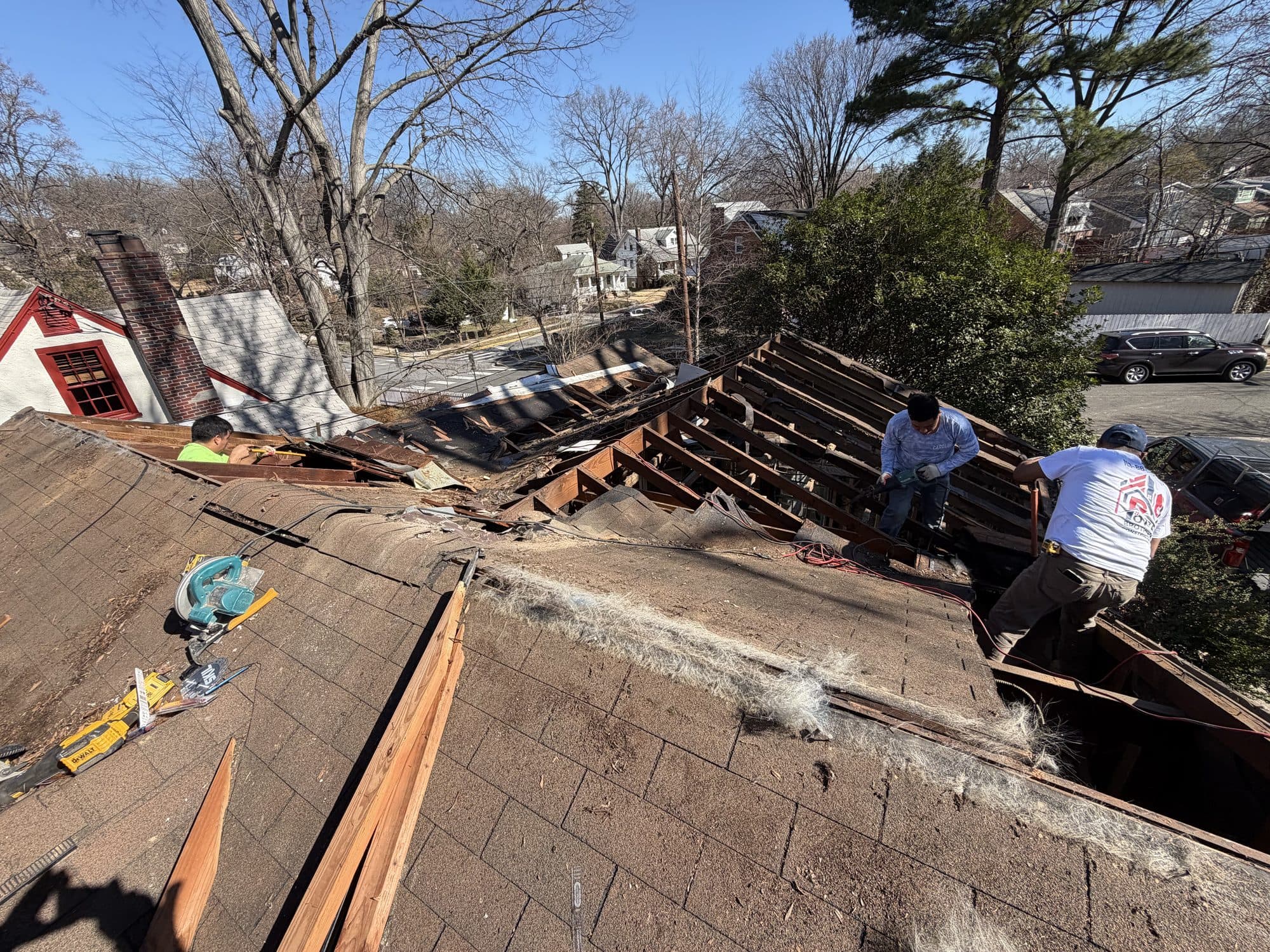 Workers reframe along the ridge during a home addition, with tools staged on the deck. Home addition project by Potts Brothers Construction, Arlington & Northern Virginia