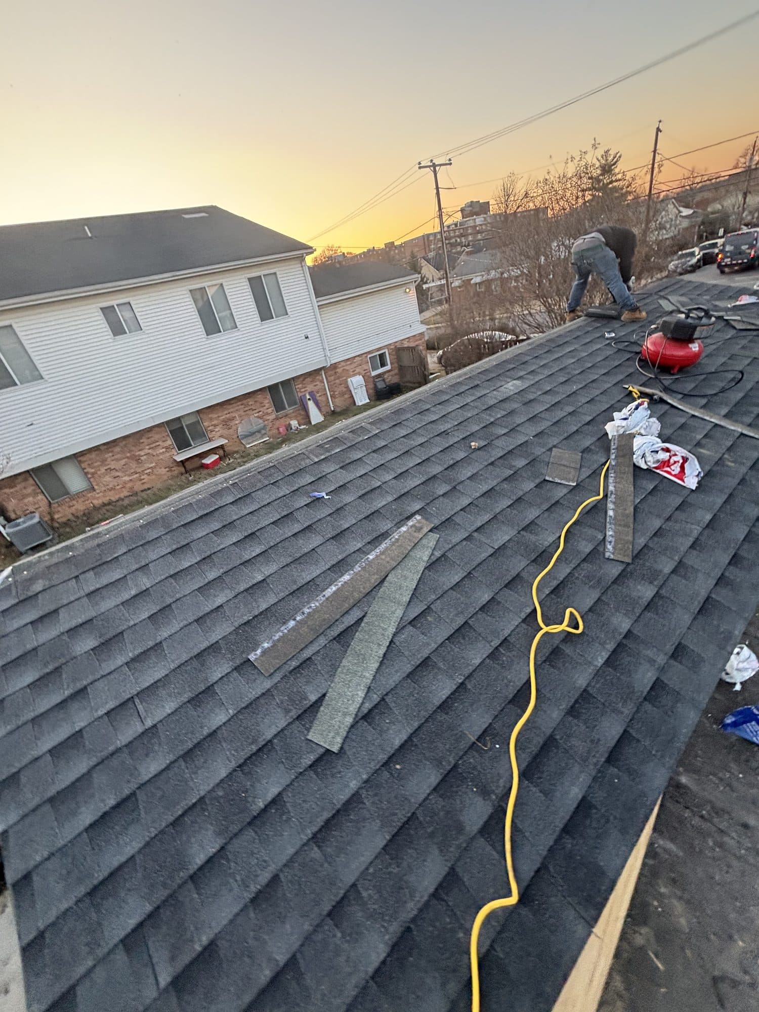 Shingle roof work at sunset on home. Home addition project by Potts Brothers Construction, Arlington & Northern Virginia