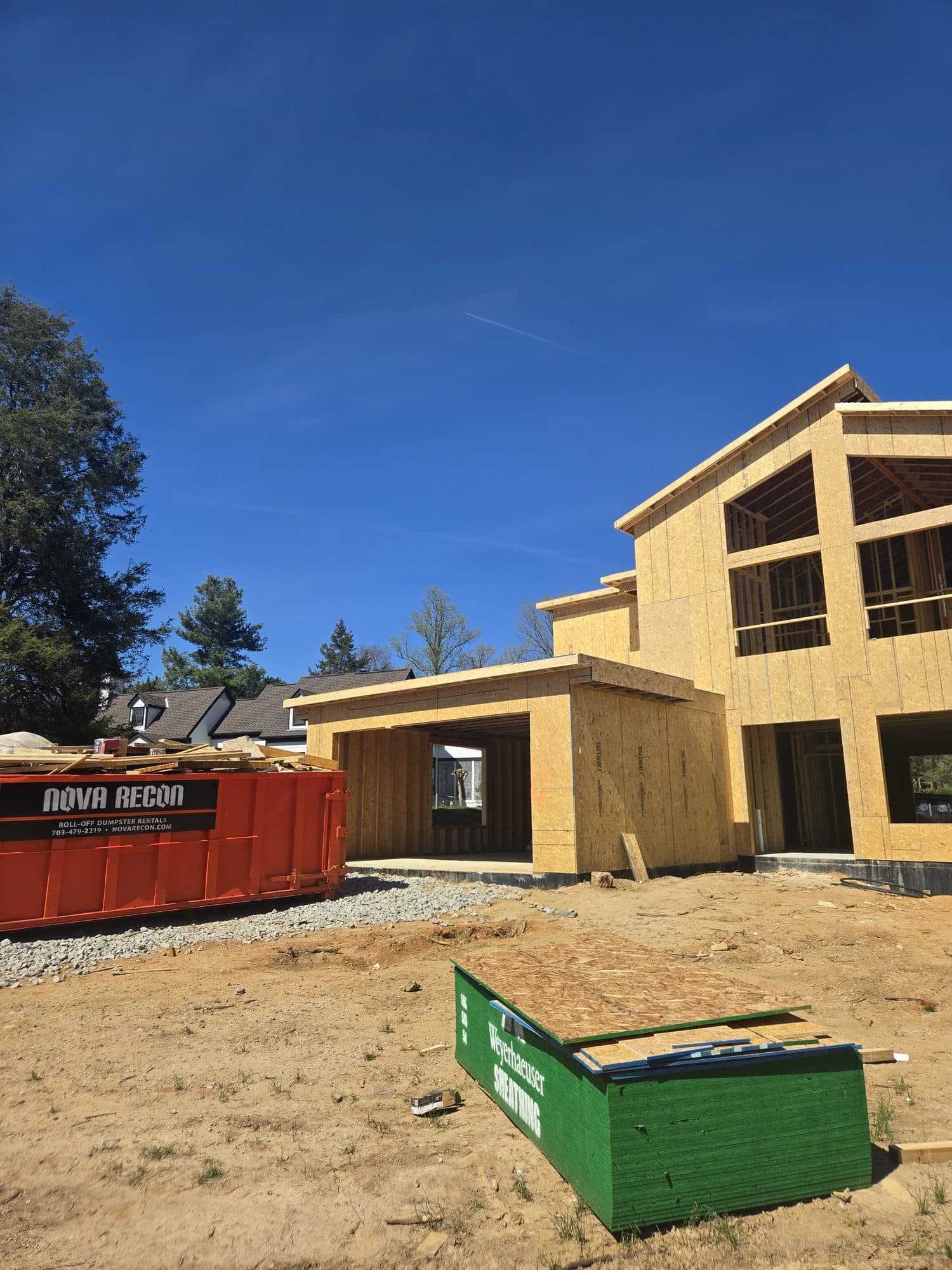 A large two-story home addition framed and partly sheathed with Tyvek-wrapped gables. Home addition project by Potts Brothers Construction, Arlington & Northern Virginia