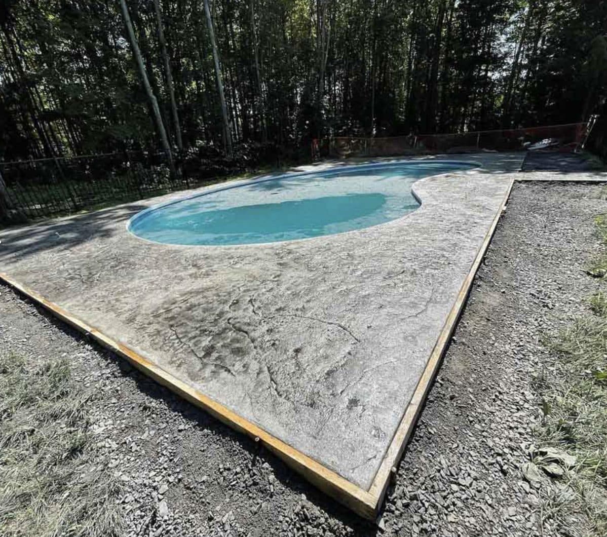 Broom-finished concrete pool deck around freeform pool. Concrete project by Potts Brothers Construction, Arlington & Northern Virginia