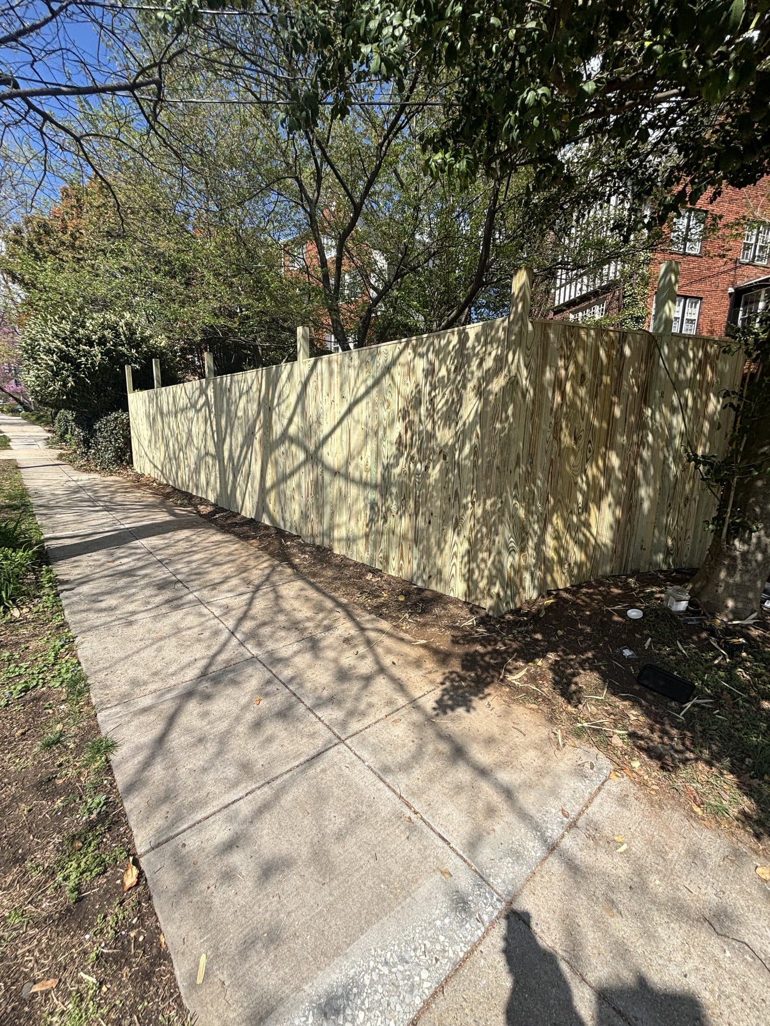 Concrete sidewalk alongside new wood privacy fen. Concrete project by Potts Brothers Construction, Arlington & Northern Virginia