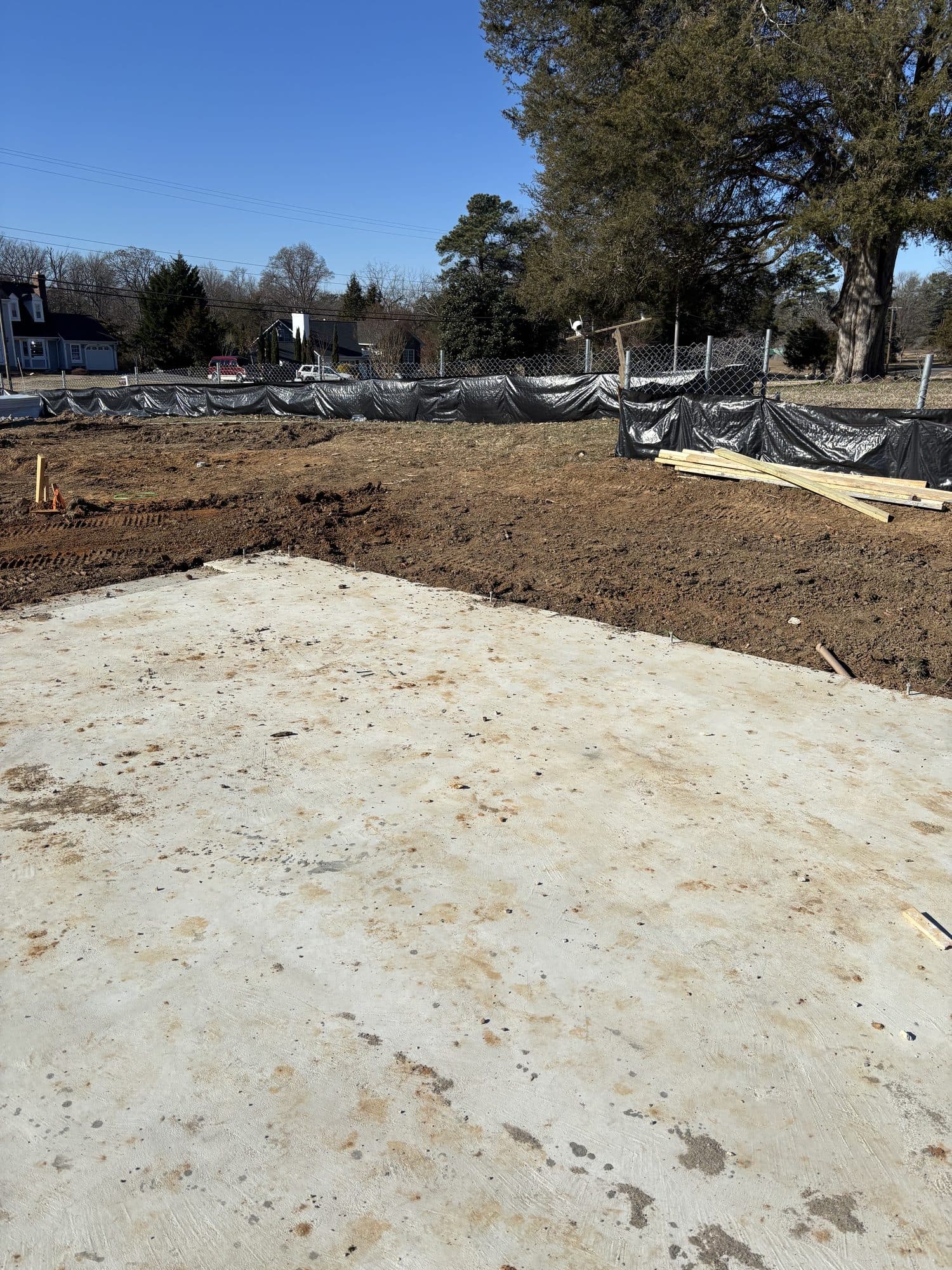 Concrete slab with silt fence and trees behind. Concrete project by Potts Brothers Construction, Arlington & Northern Virginia