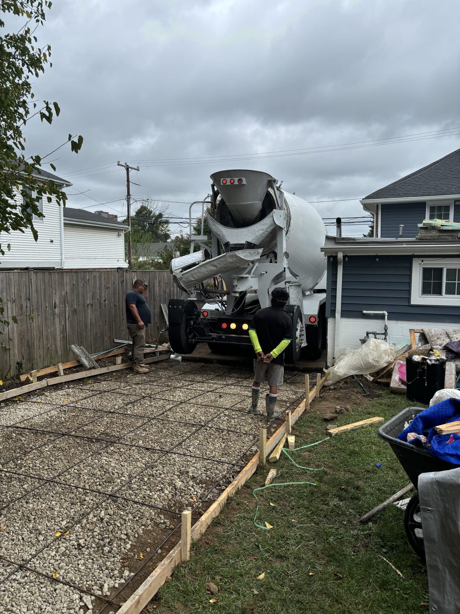 Concrete truck pouring driveway slab with crew. Concrete project by Potts Brothers Construction, Arlington & Northern Virginia