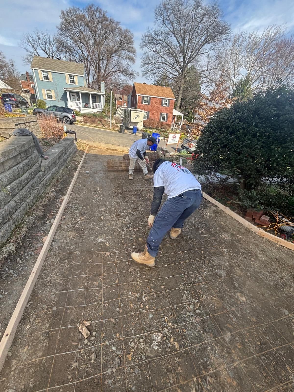 Crew placing rebar mesh driveway. Concrete project by Potts Brothers Construction, Arlington & Northern Virginia