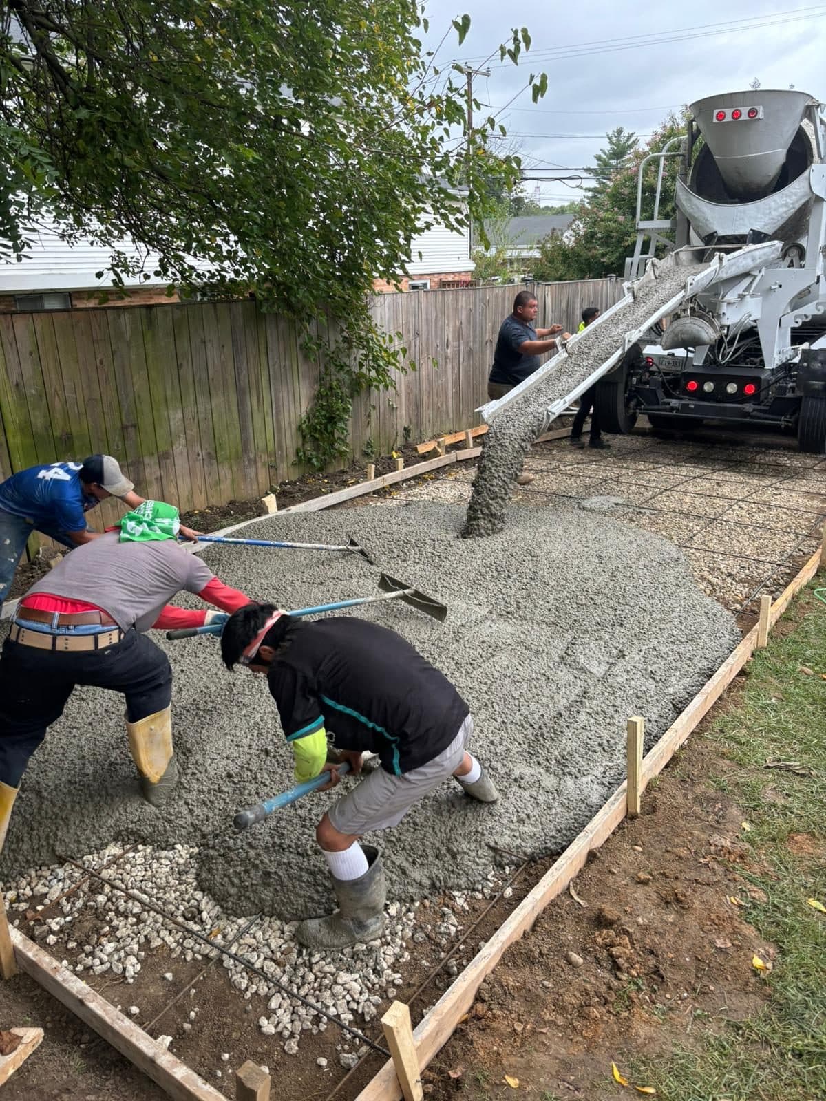 Crew placing wet concrete from a mixer truck int. Concrete project by Potts Brothers Construction, Arlington & Northern Virginia