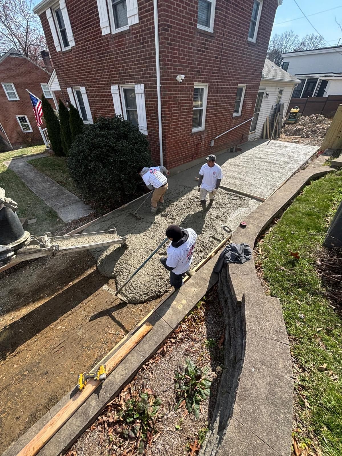Crew pouring concrete walkway side. Concrete project by Potts Brothers Construction, Arlington & Northern Virginia