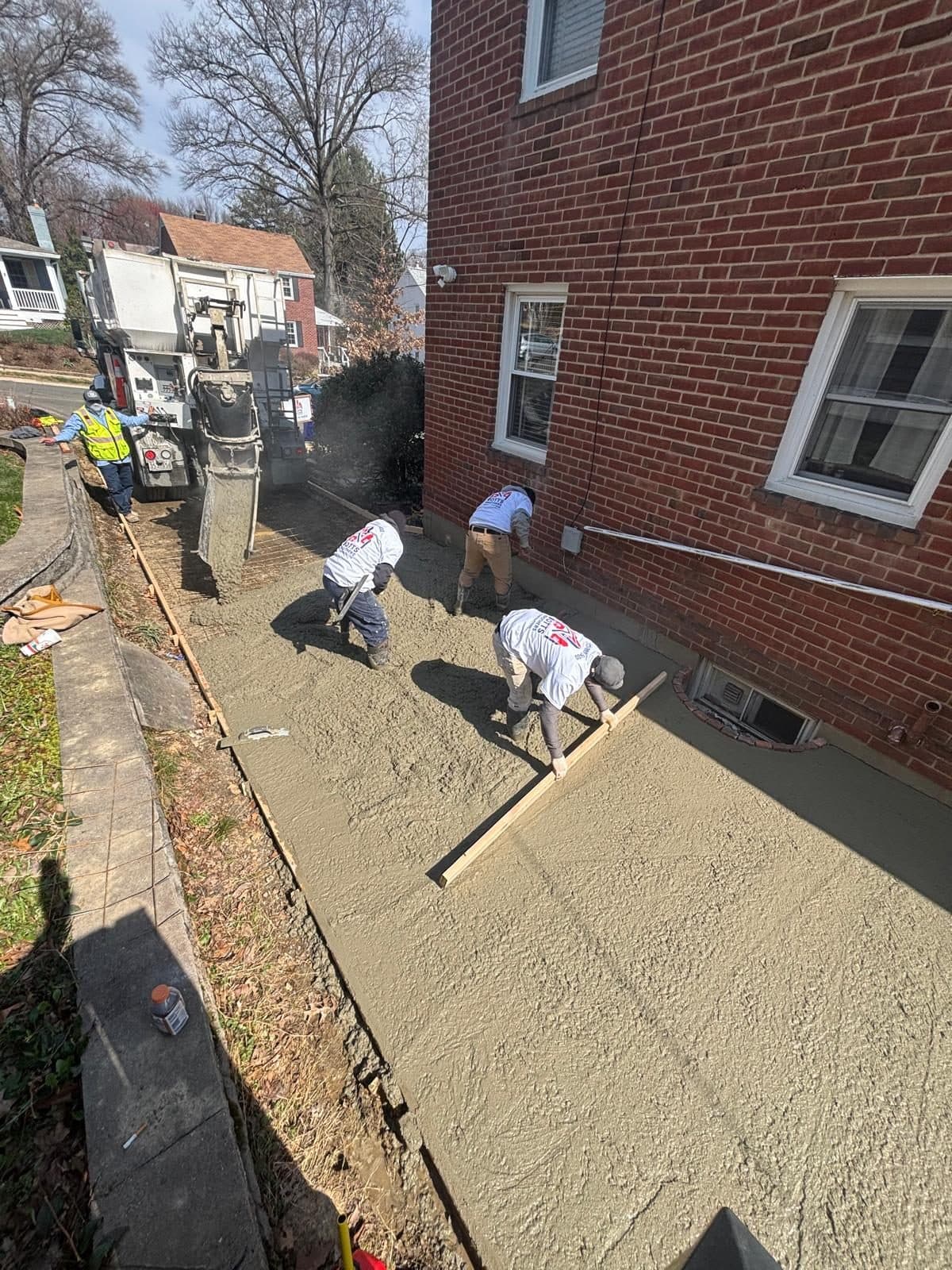 Crew pouring screeding concrete walkway. Concrete project by Potts Brothers Construction, Arlington & Northern Virginia