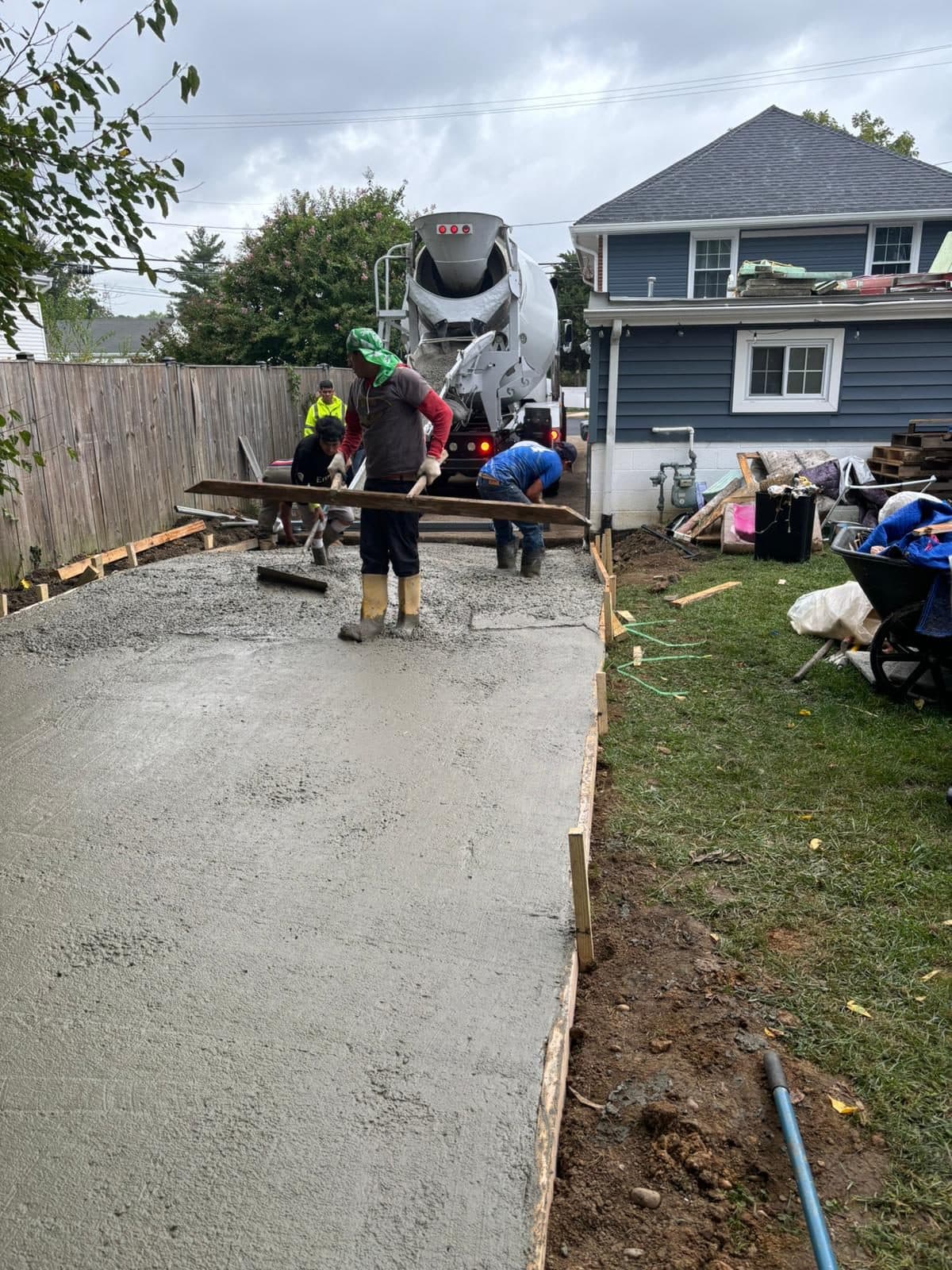 Crew screeding a freshly poured concrete walkway. Concrete project by Potts Brothers Construction, Arlington & Northern Virginia