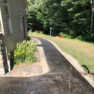 Curving concrete walkway beside house with gravel border. Concrete project by Potts Brothers Construction, Arlington & Northern Virginia