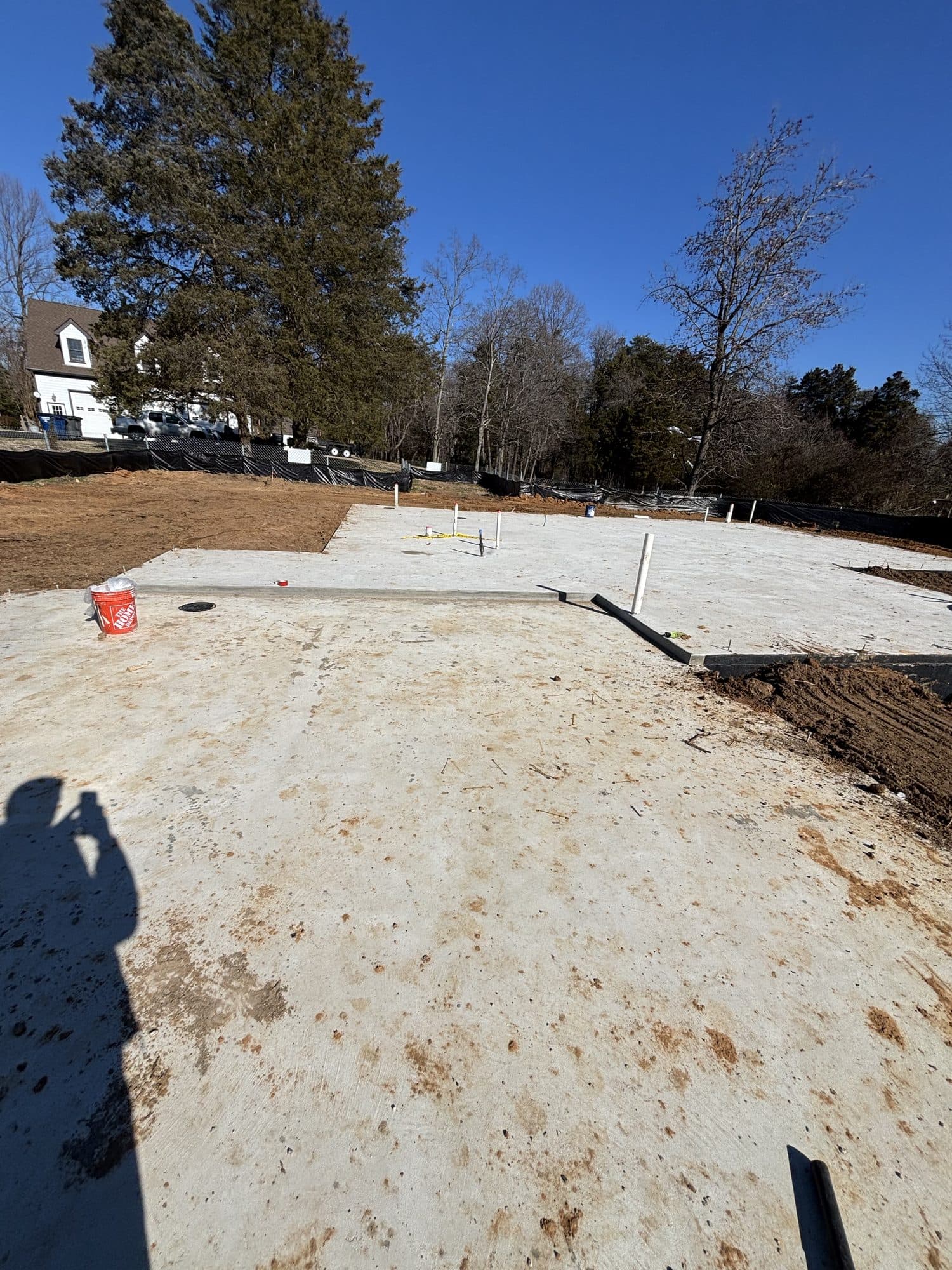 Fresh concrete slab on grade with homes behind. Concrete project by Potts Brothers Construction, Arlington & Northern Virginia