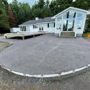Large curved concrete patio behind white house. Concrete project by Potts Brothers Construction, Arlington & Northern Virginia