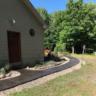 Stamped concrete walkway curving past landscaped home. Concrete project by Potts Brothers Construction, Arlington & Northern Virginia