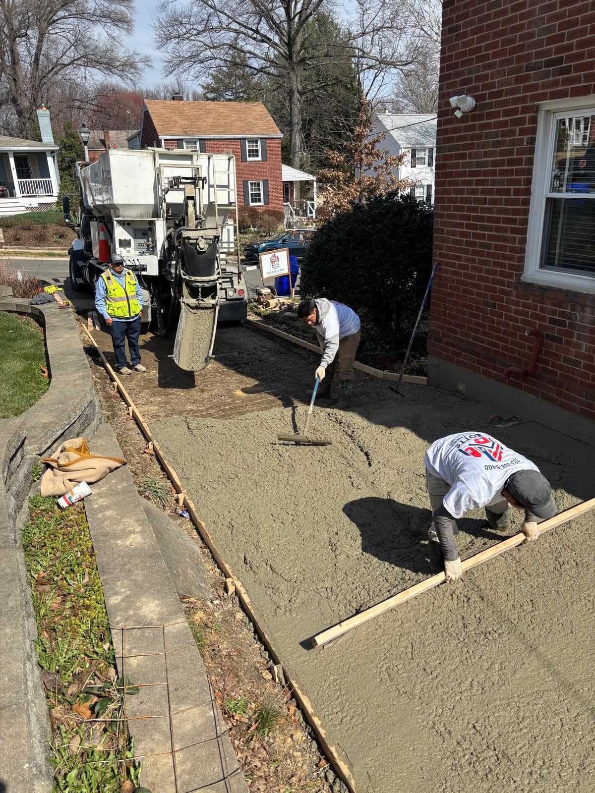 Workers floating fresh concrete slab. Concrete project by Potts Brothers Construction, Arlington & Northern Virginia