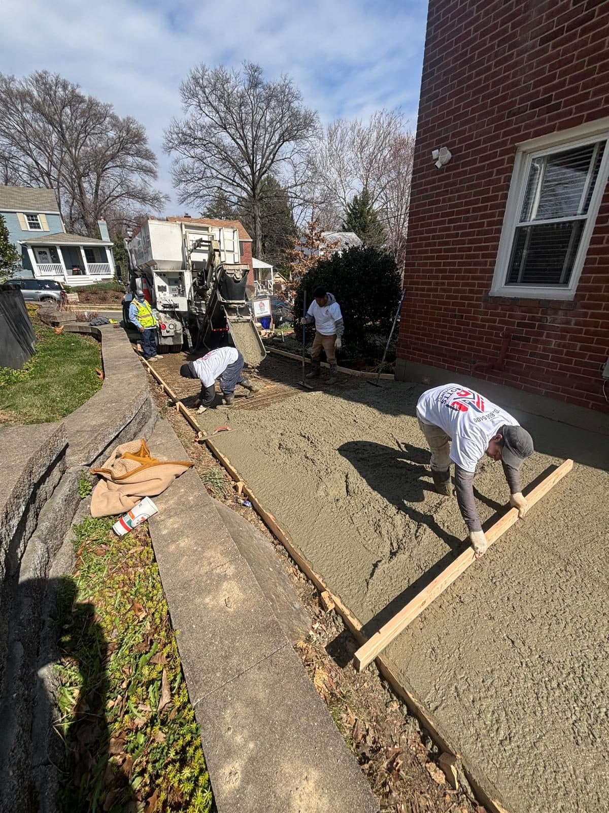 Workers screeding fresh concrete slab. Concrete project by Potts Brothers Construction, Arlington & Northern Virginia