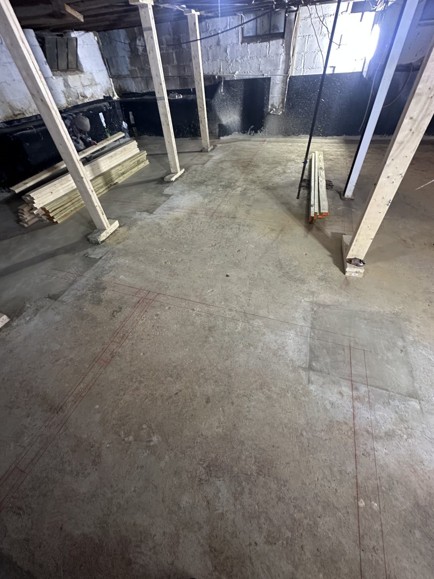 Empty basement with poured concrete floor and posts. Foundation project by Potts Brothers Construction, Arlington & Northern Virginia