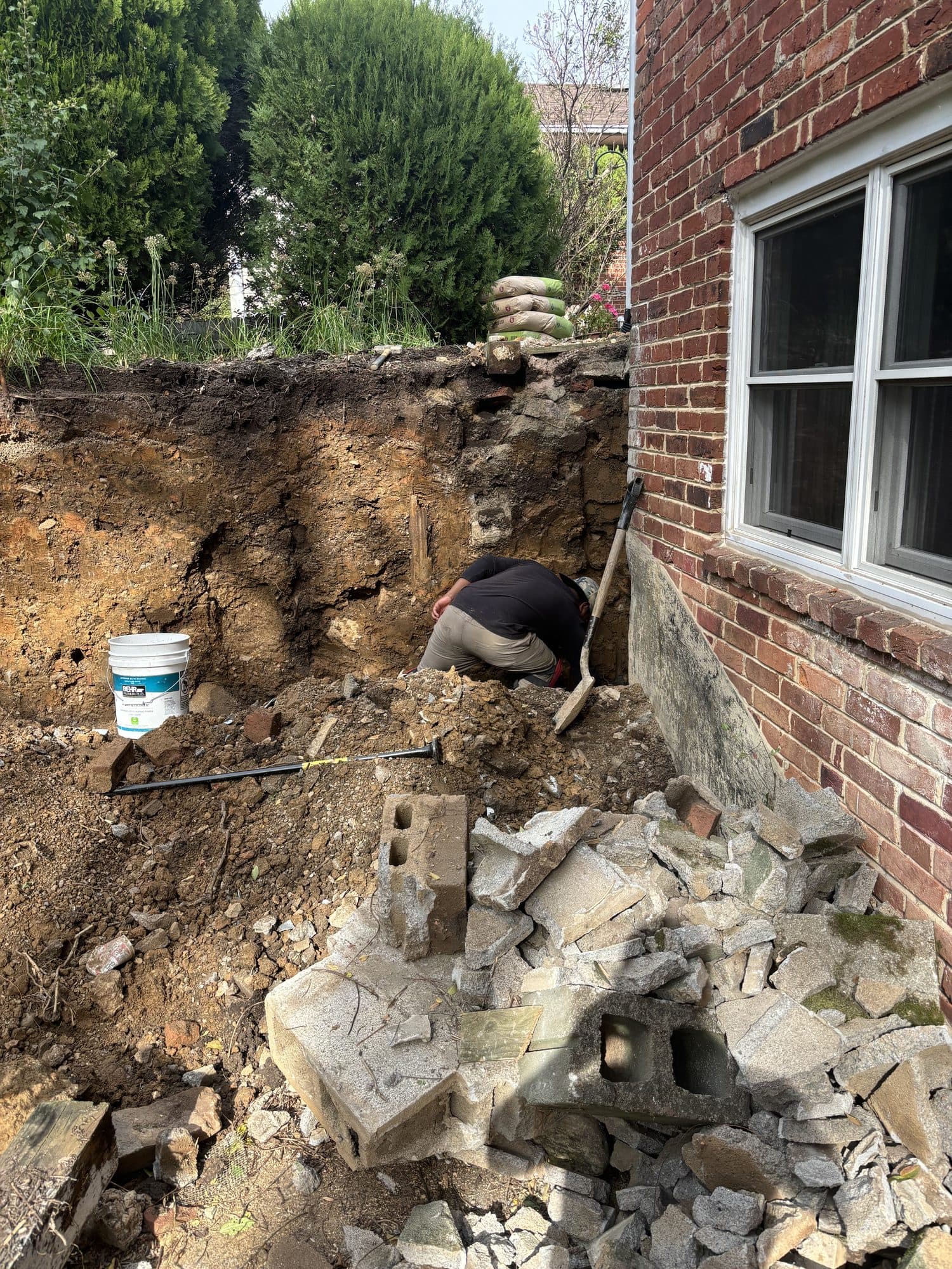 Excavation brick house foundation worker. Foundation project by Potts Brothers Construction, Arlington & Northern Virginia