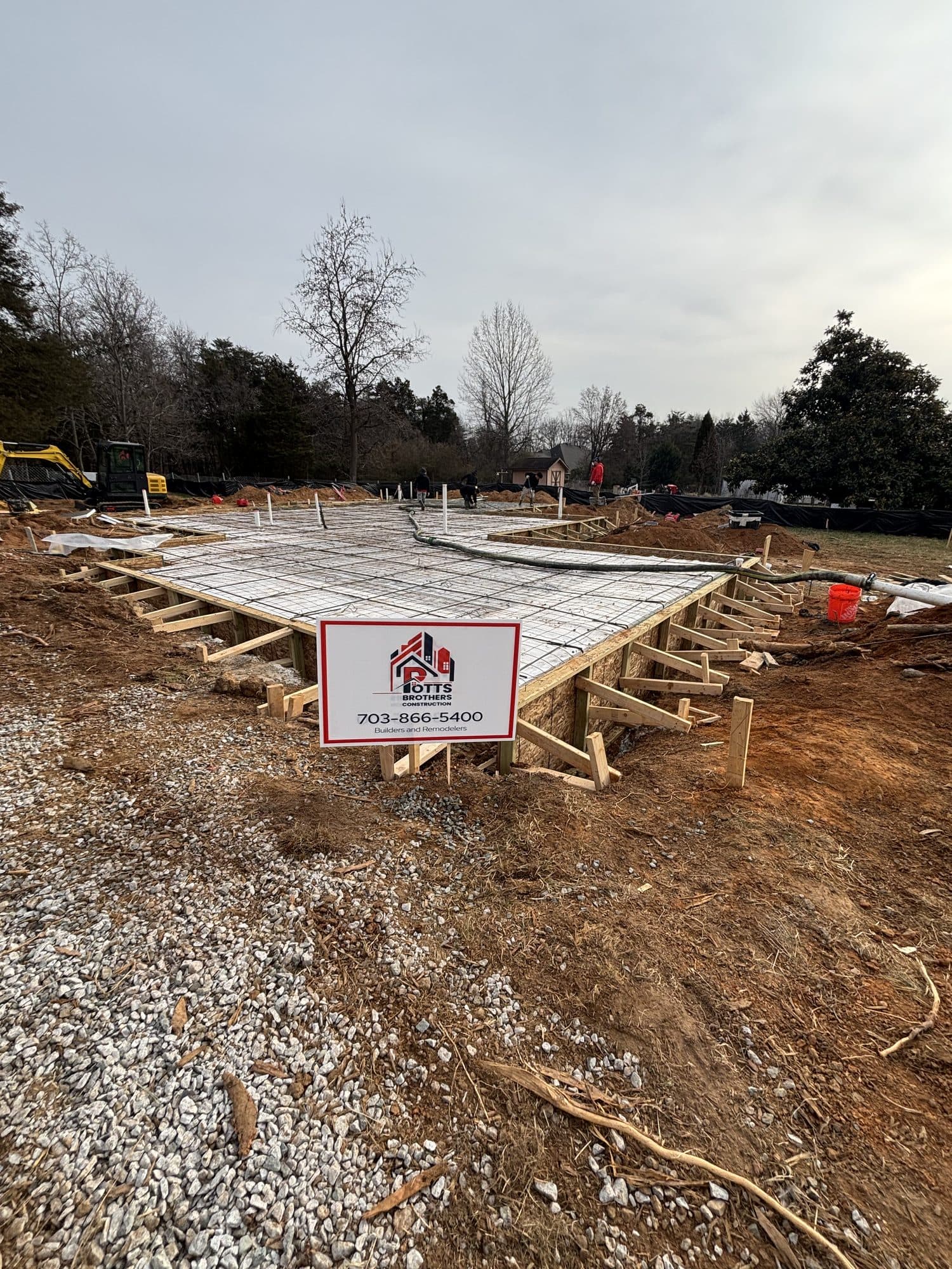 Slab foundation with rebar mat and company sign. Foundation project by Potts Brothers Construction, Arlington & Northern Virginia