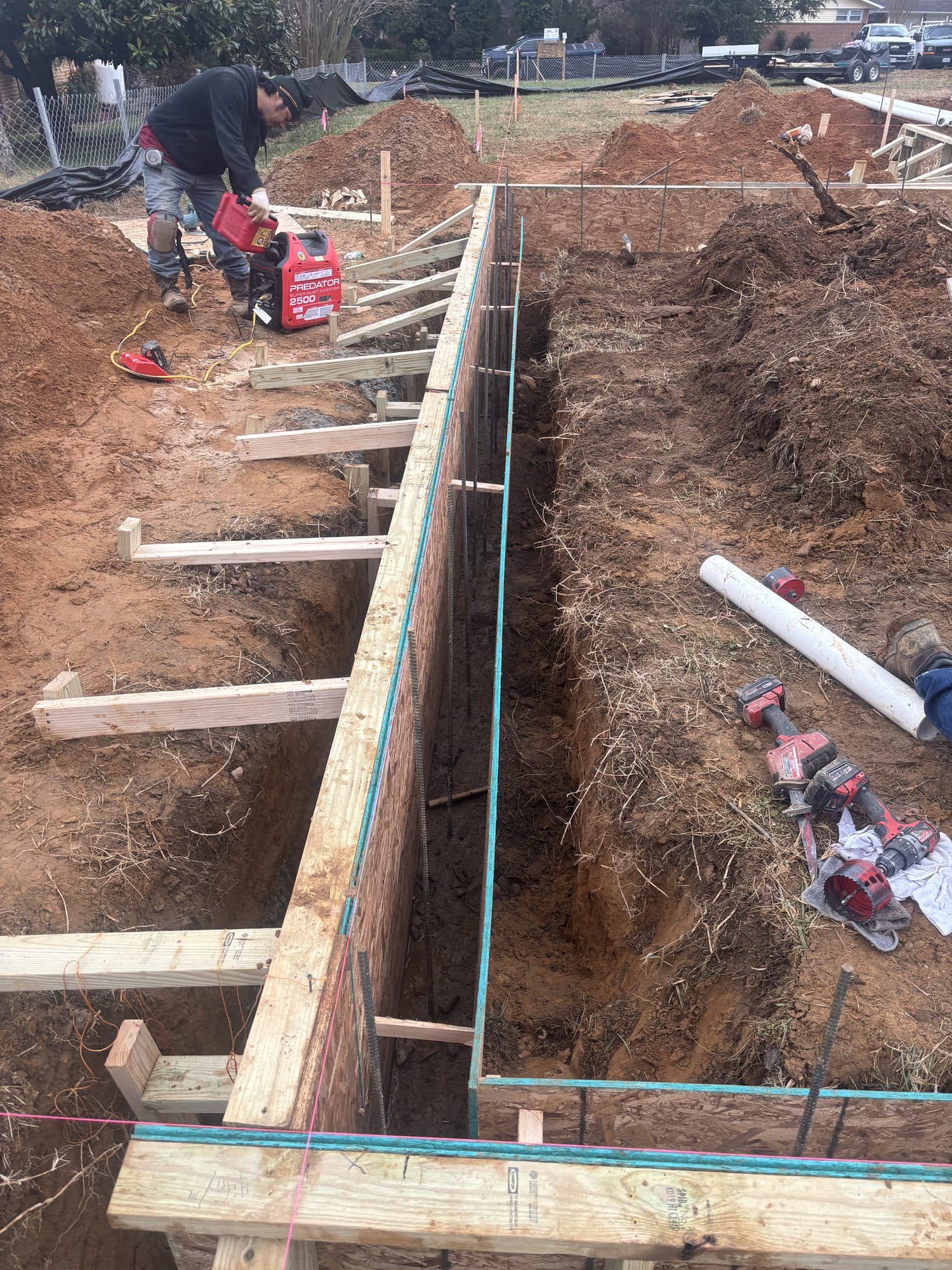 Worker building footing formwork in deep trench. Foundation project by Potts Brothers Construction, Arlington & Northern Virginia